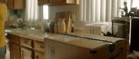 a woman standing in a kitchen with a box on the counter