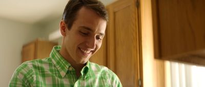 a man in a green and white shirt smiling