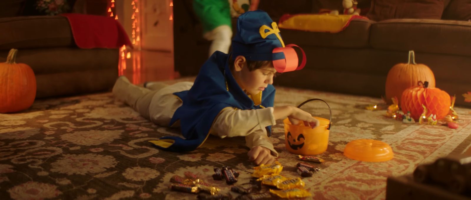 a little boy in a costume playing with halloween decorations