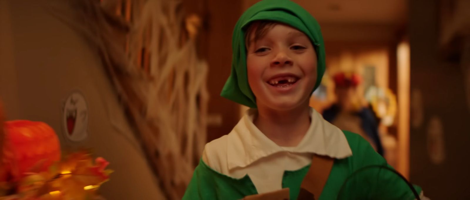 a young boy dressed in a green costume