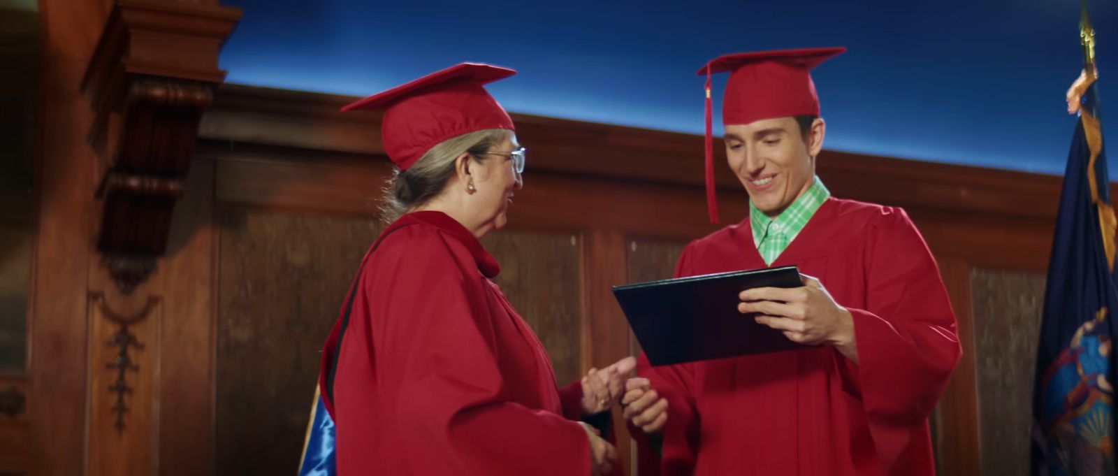 a man and a woman in red graduation gowns