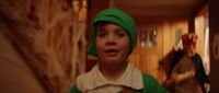 a young boy wearing a green hat and green sweater