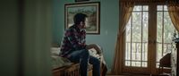 a man sitting on top of a bed in a bedroom