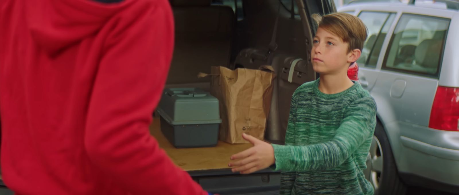 a young boy standing in front of a van