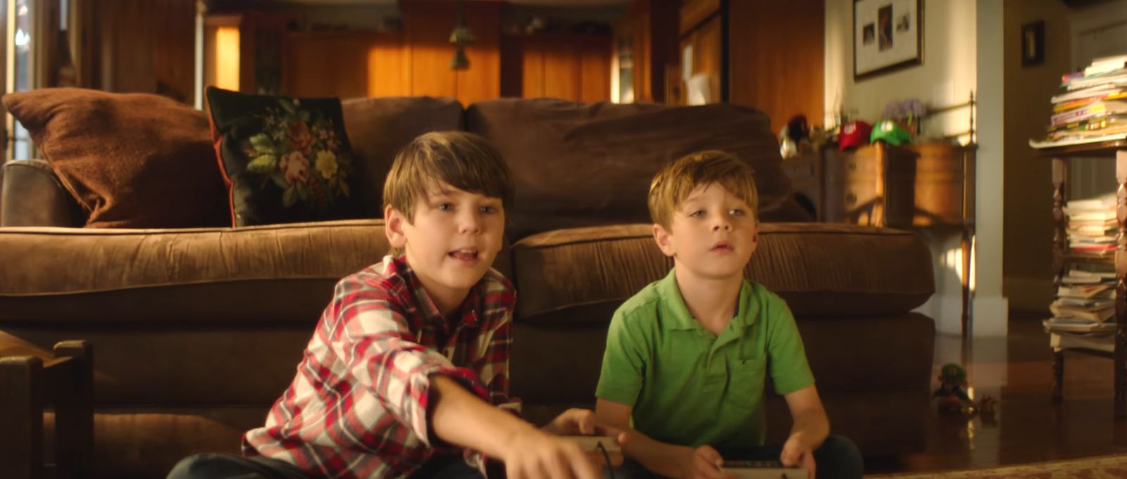 two young boys sitting on the floor playing a video game