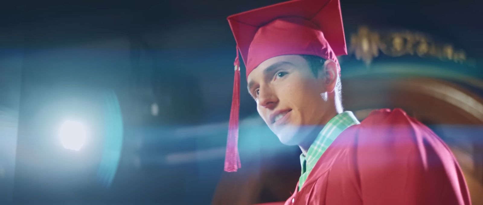 a young man in a red cap and gown