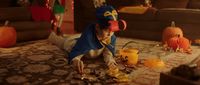 a little boy in a costume playing with halloween decorations