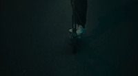 a man riding a skateboard down a dark street