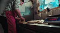 a man in a kitchen preparing food on a cutting board