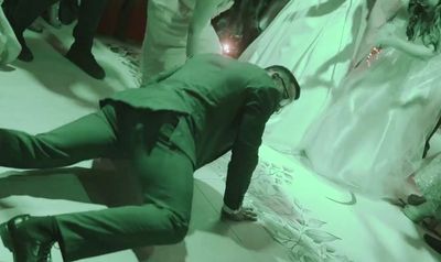 a man in a green suit is laying on the floor