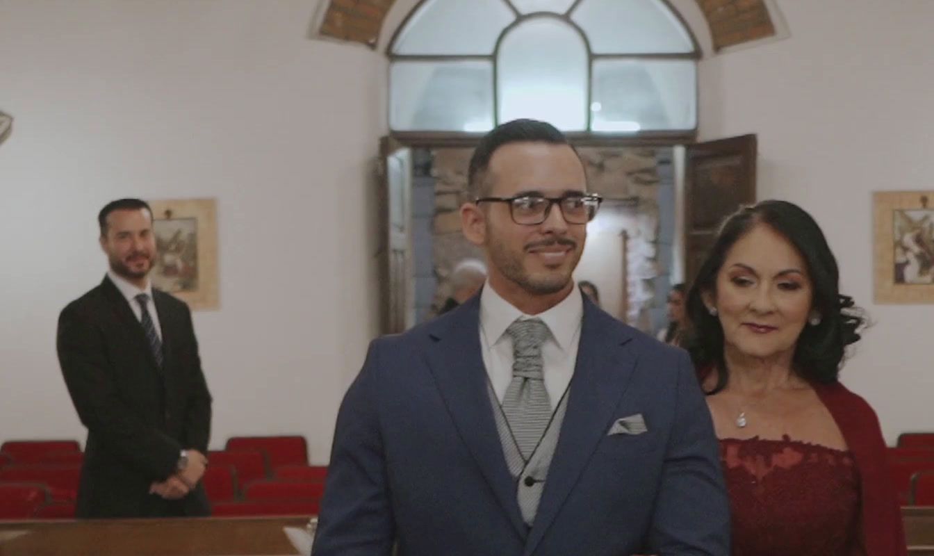 a man in a suit standing next to a woman in a red dress