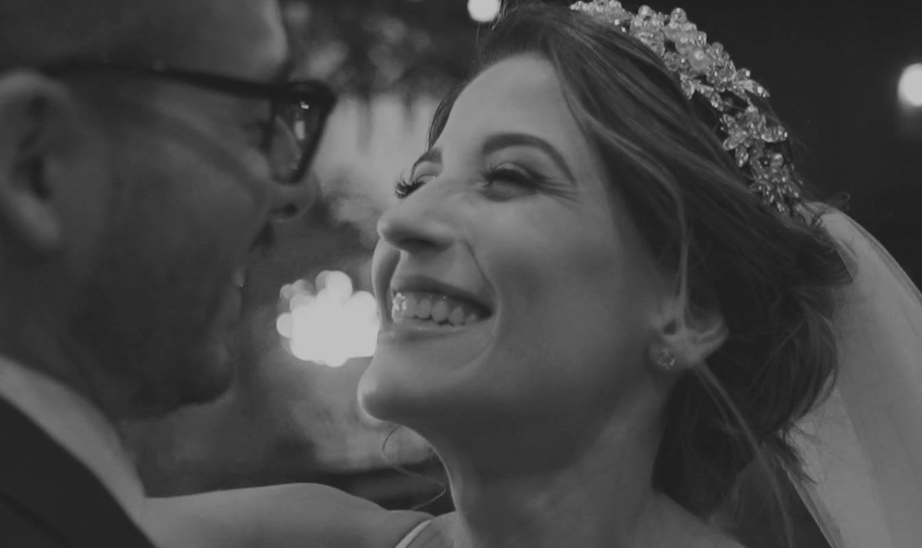 a woman in a wedding dress smiles at a man in a suit