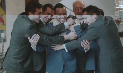 a group of men in suits hugging each other