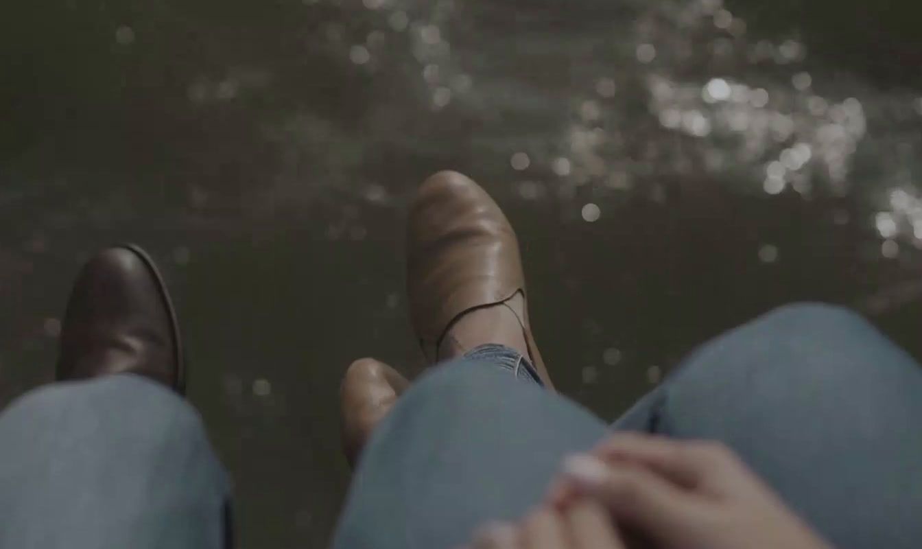 a close up of a person's feet with water in the background