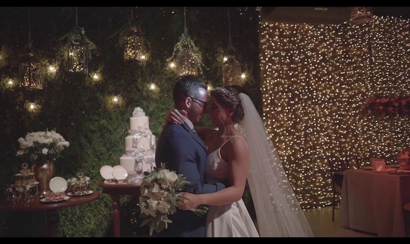 a bride and groom standing in front of a cake