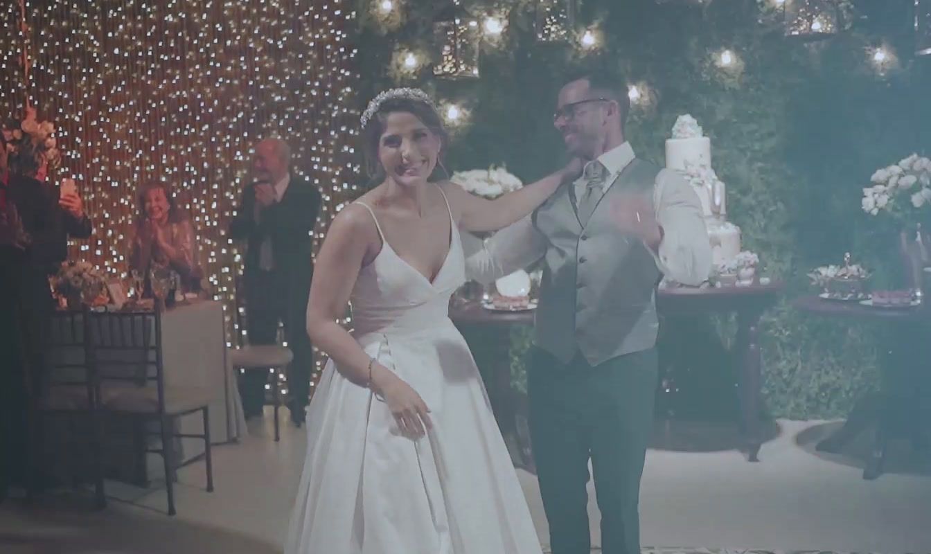 a man and a woman standing next to each other in front of a cake