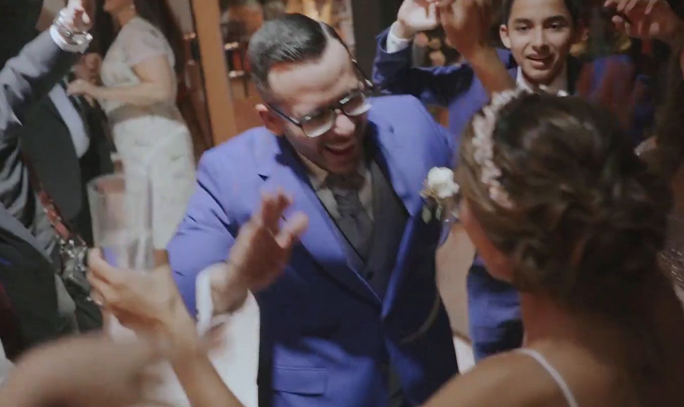 a man in a blue suit dancing with other people