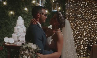 a man and a woman standing next to each other in front of a cake