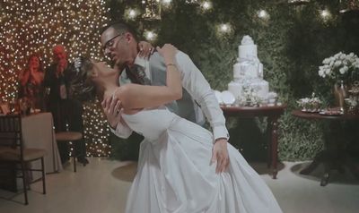 a man and a woman dance together in front of a christmas tree