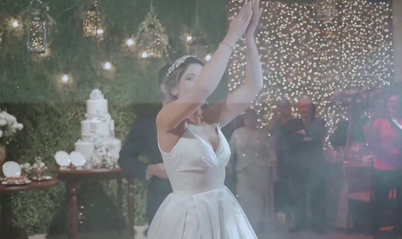 a woman in a white dress standing in front of a cake