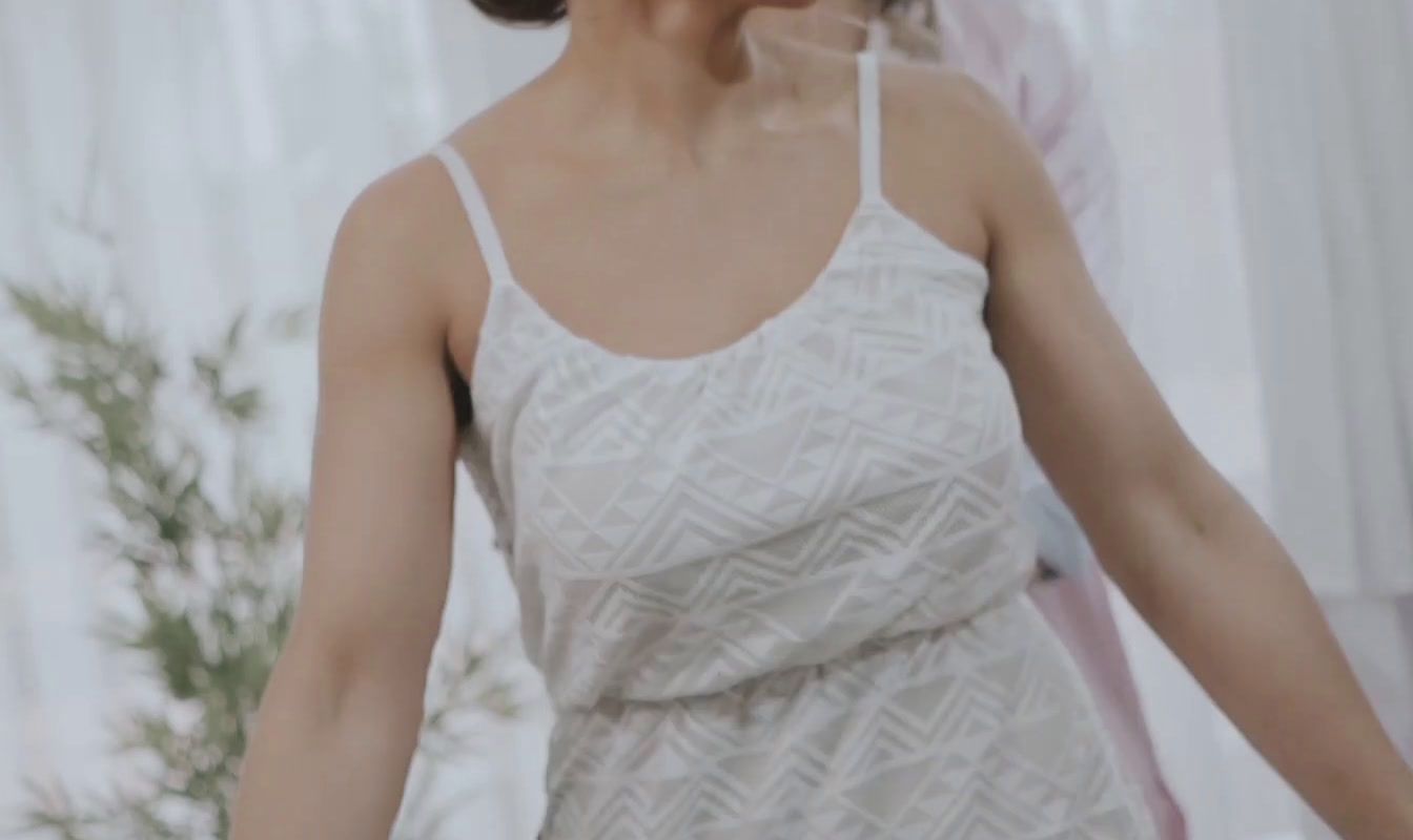 a woman in a white dress holding a white frisbee