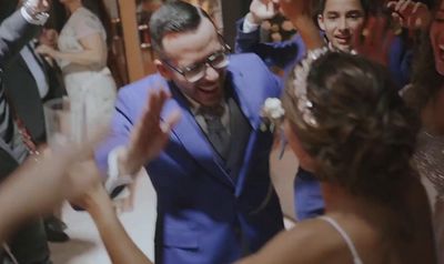 a man in a blue suit dancing with other people