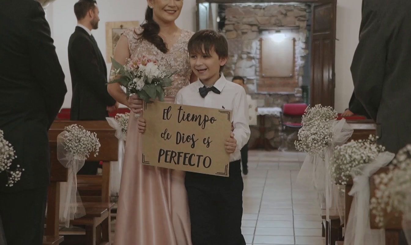 a young boy and woman standing next to each other holding a sign