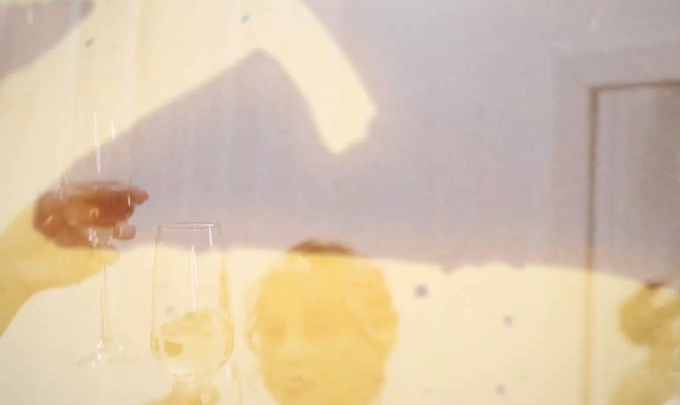 a reflection of a person holding a wine glass