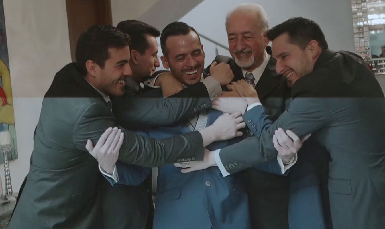 a group of men in suits hugging each other