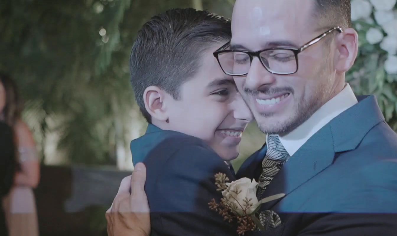 a man in a suit hugging a boy in a suit