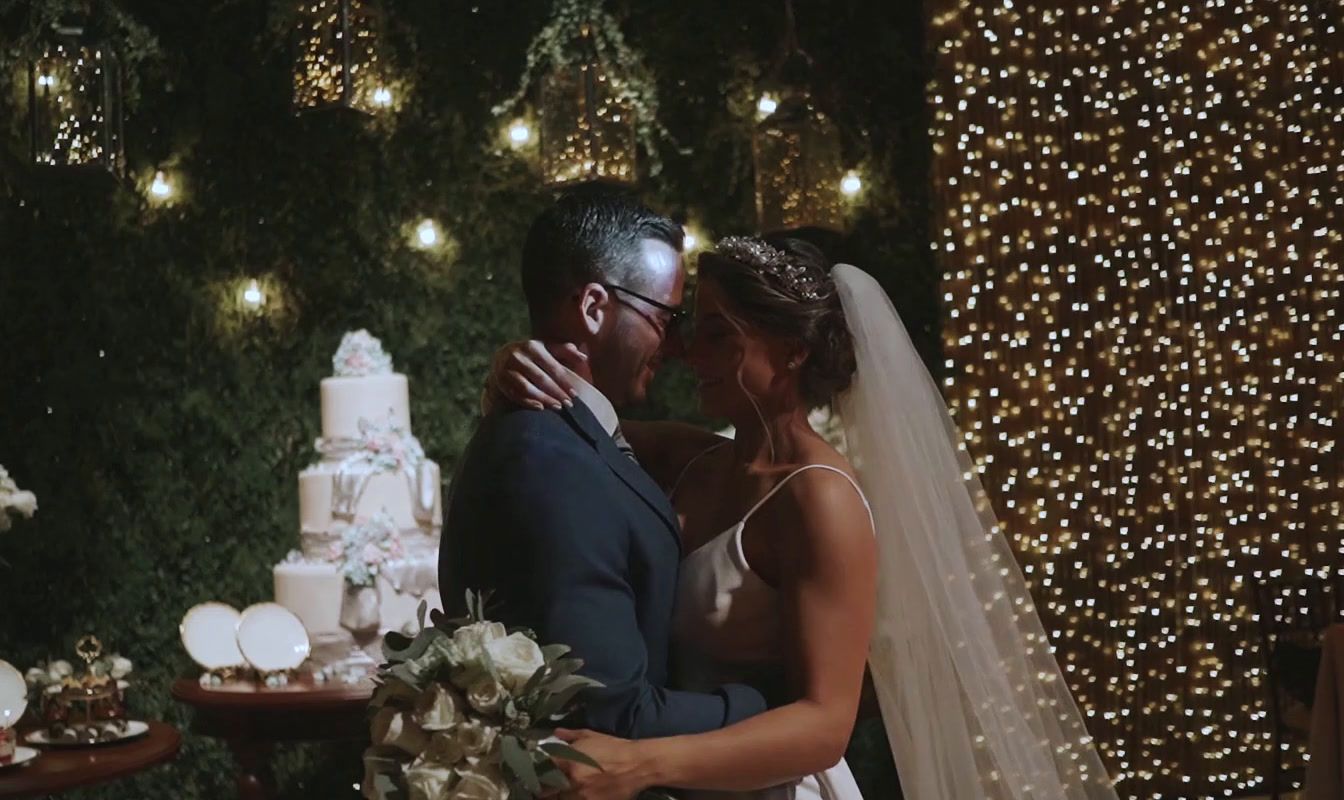 a bride and groom standing in front of a wedding cake