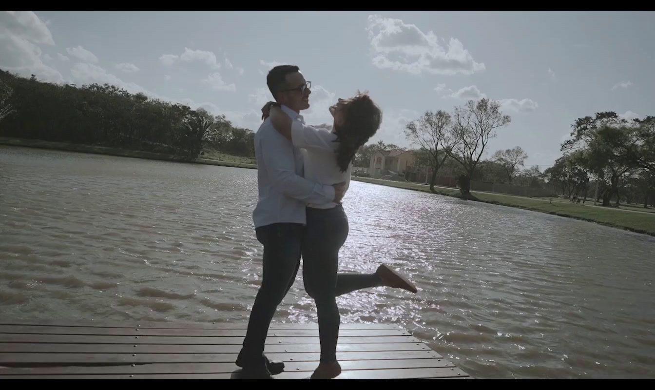 a man and woman standing on a dock near a body of water