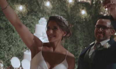 a woman in a white dress standing next to a man in a suit