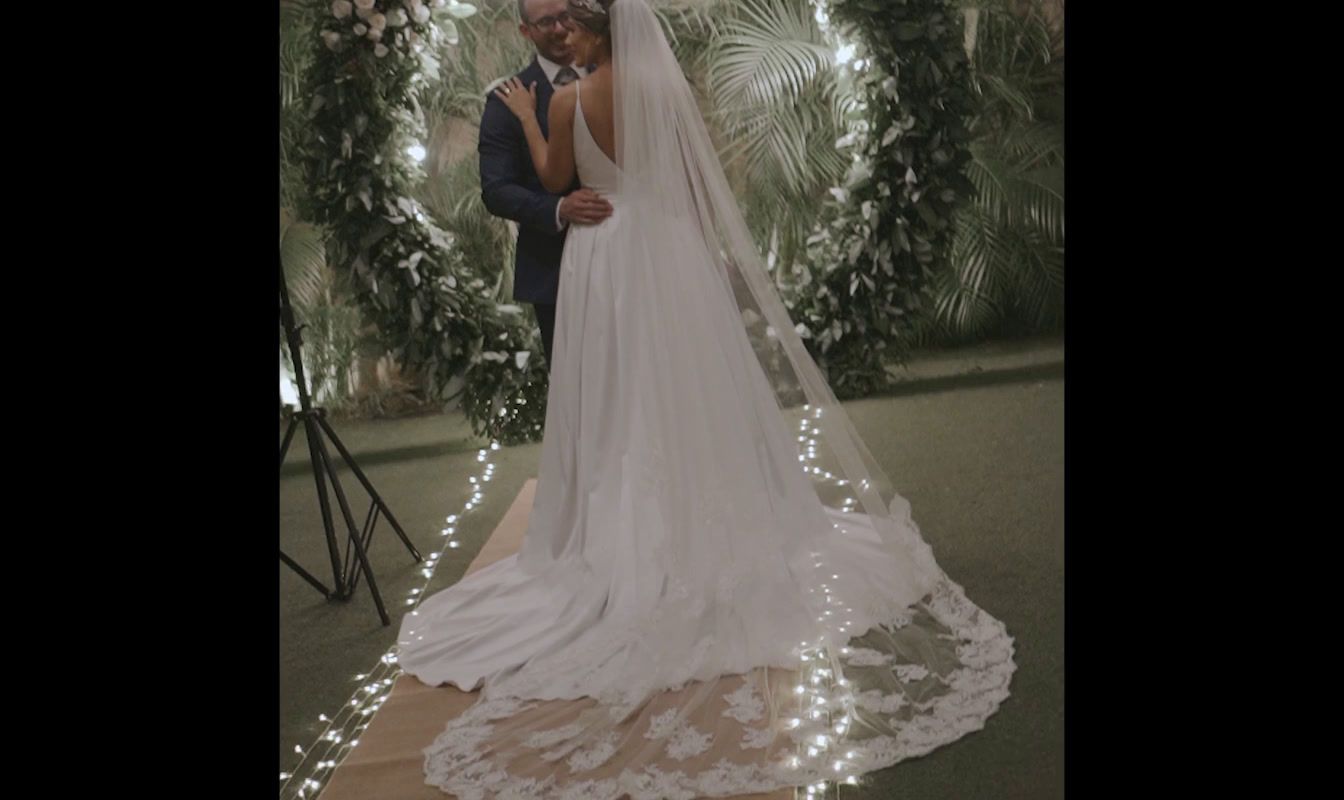 a man and a woman standing in front of a wedding arch