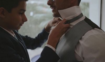 a man helping a boy fix his tie