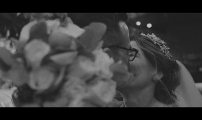 a bride and groom kissing in a black and white photo