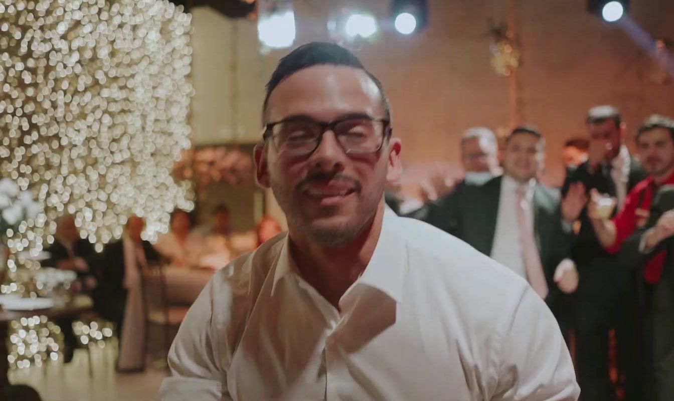 a man in a white shirt and tie standing in front of a group of people