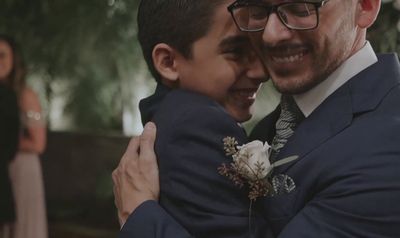 a man in a suit hugging a boy in a suit