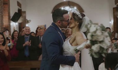 a bride and groom kissing in front of a crowd of people