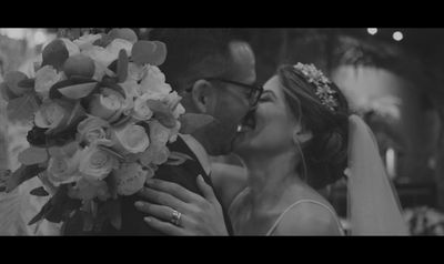 a bride and groom kissing in a black and white photo