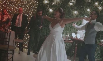 a bride and groom are dancing in front of their guests