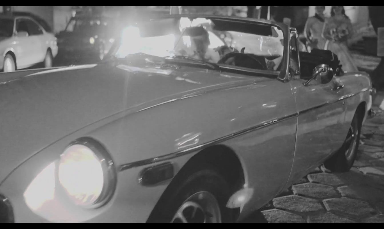 a black and white photo of a man driving a car