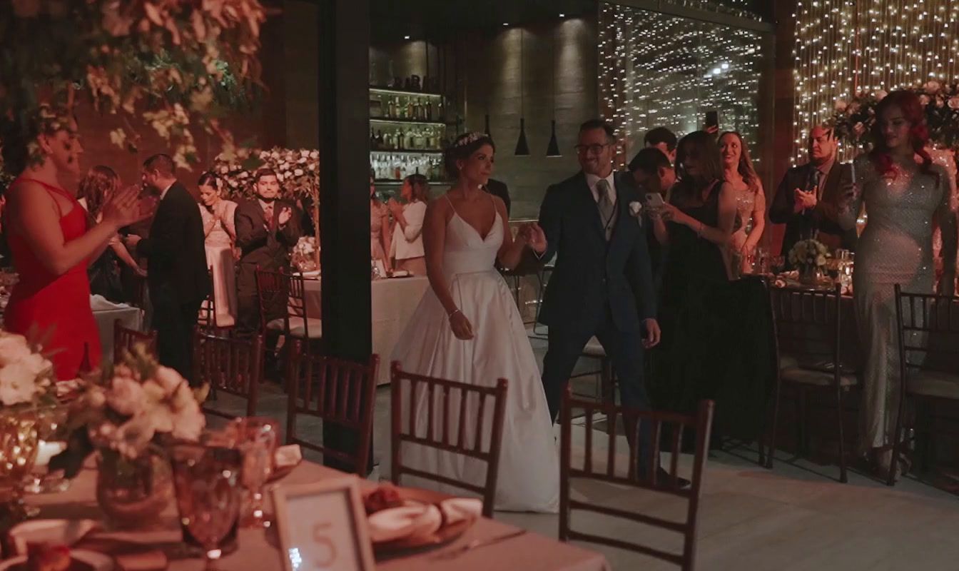 a bride and groom walking through a wedding reception