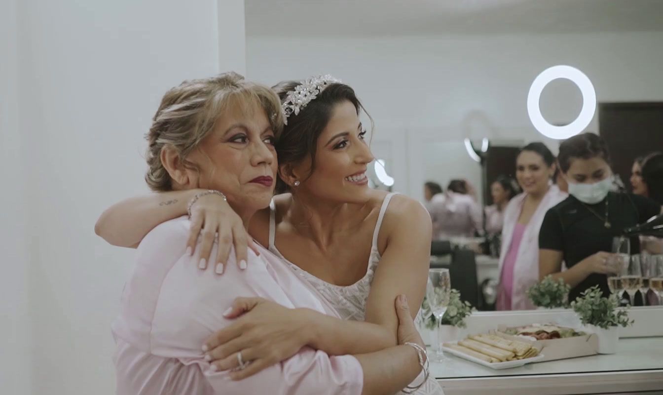 two women hugging each other in front of a mirror