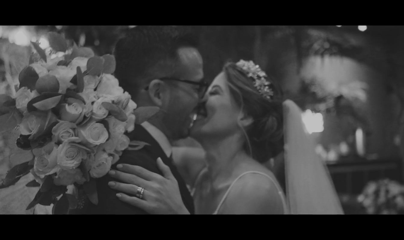 a bride and groom kissing in a black and white photo