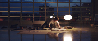 a man working on a piece of paper in a room