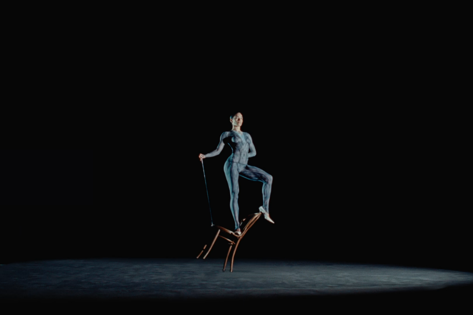 a woman sitting on top of a chair in the dark