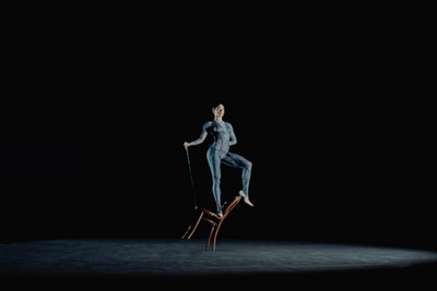 a woman sitting on top of a chair in the dark