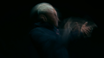 a blurry image of a man in a dark room