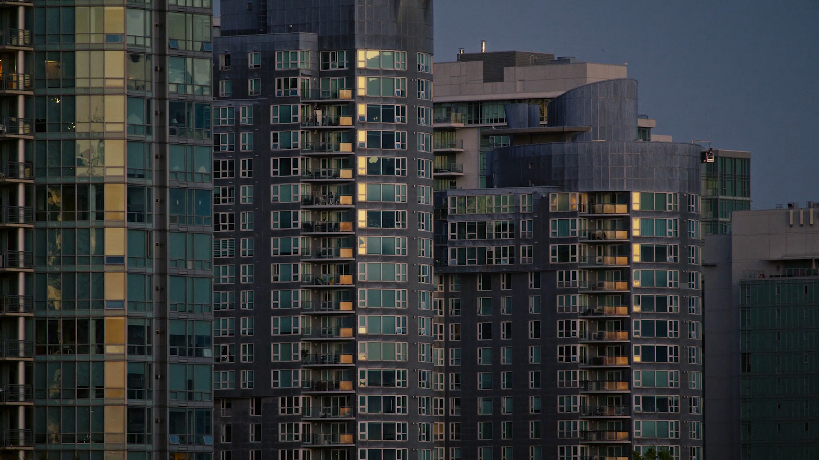 a plane is flying in front of some tall buildings